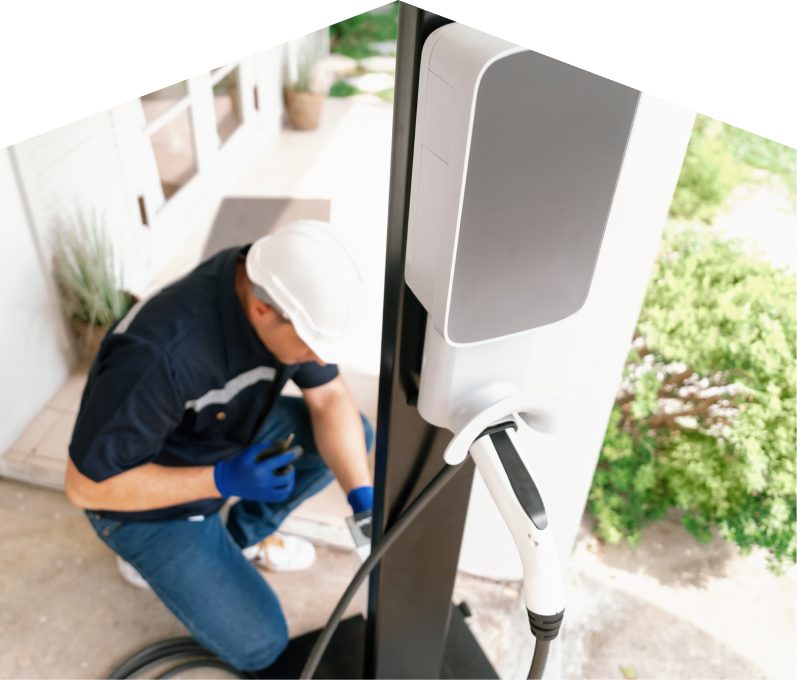 Home service electrician from Furnace Guys installing an EV charger fixed to a vertical post near a residential entryway. Home service electrician from Furnace Guys installing an EV charger fixed to a vertical post near a residential entryway.