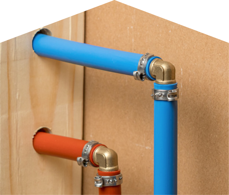 Furnace Guys kitec plumbing system with blue and orange plastic pipes connected by brass fittings and metal clamps, mounted on a wooden panel. Furnace Guys kitec plumbing system with blue and orange plastic pipes connected by brass fittings and metal clamps, mounted on a wooden panel.