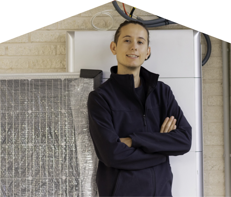 Furnace Guys specialist standing confidently with arms crossed beside newly delivered system components, including a wrapped panel and wall-mounted utility unit. Furnace Guys specialist standing confidently with arms crossed beside newly delivered system components, including a wrapped panel and wall-mounted utility unit.